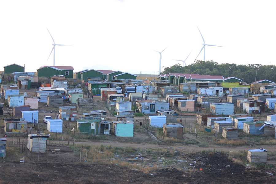 Informal settlement with wind turbines in the background